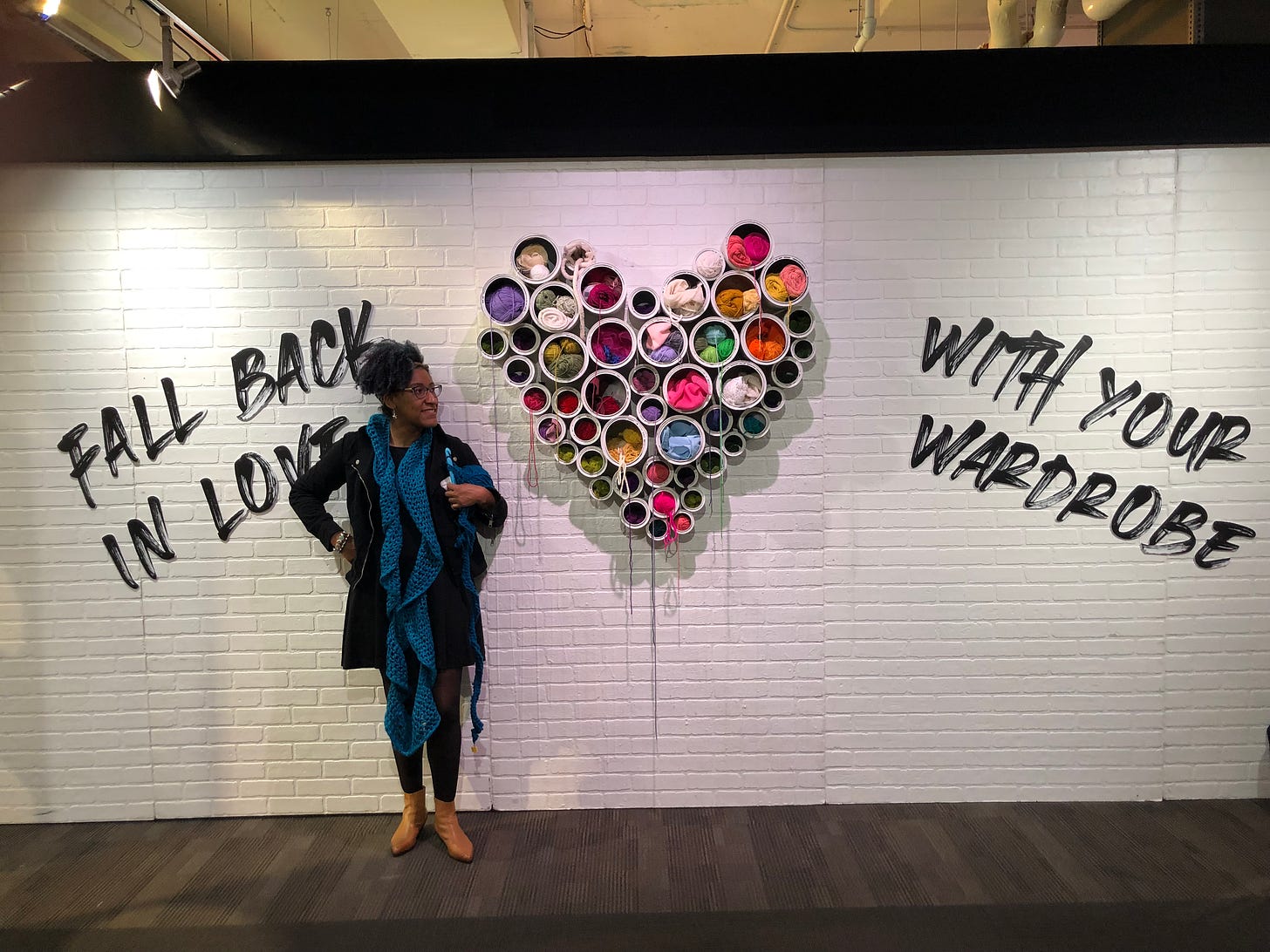 Kristen next to wall of yarn in shape of heart