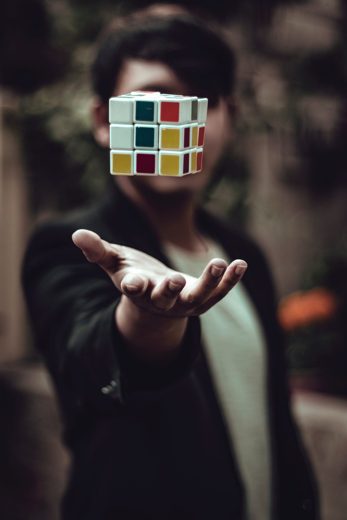 Man tossing rubic cube toward the viewer