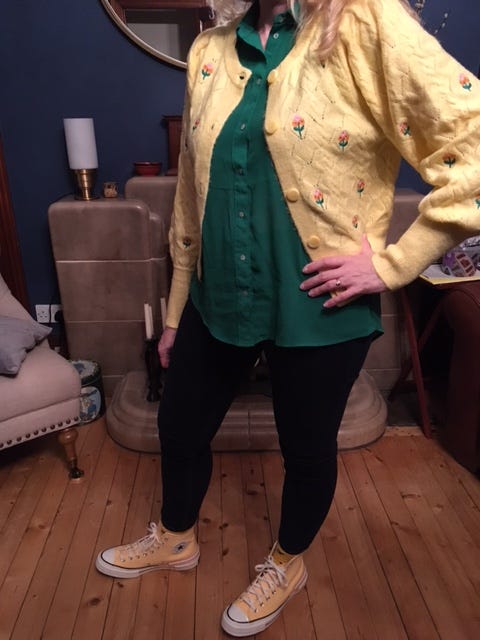standing in room in yellow sweater and yellow sneakers