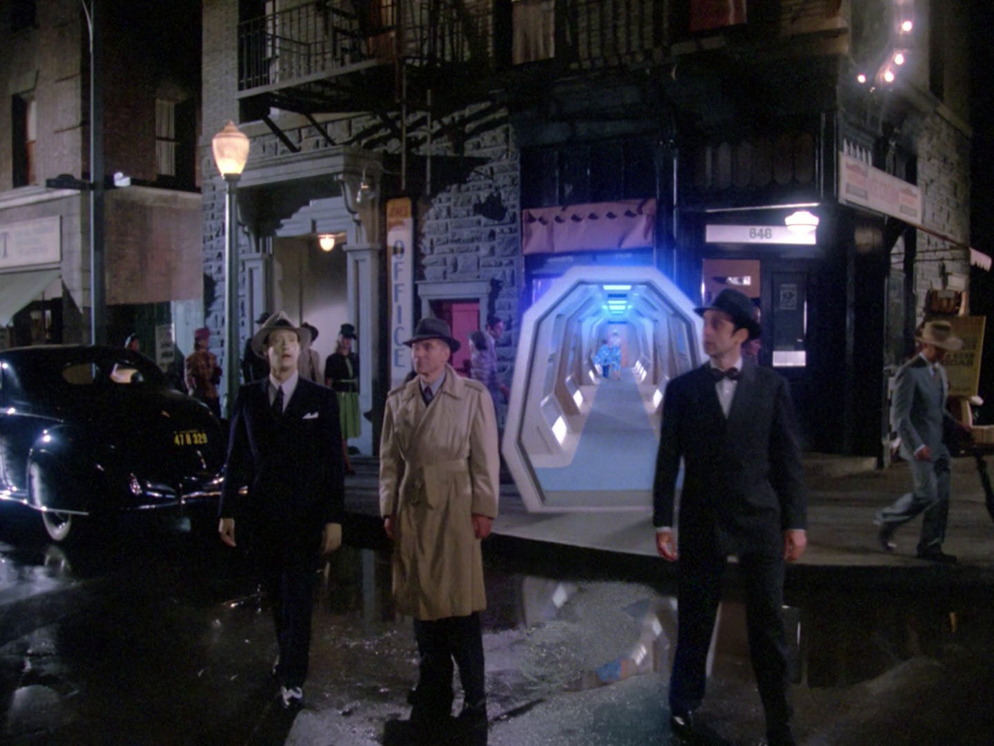 This image shows Lieutenant Commander Data (played by Brent Spiner), Captain Jean-Luc Picard (played by Patrick Stewart), and ship's historian Whalen (played by David Selburg) entering the Enterprise-D's holodeck in the Season 1 episode "The Big Goodbye." All three men are dressed in clothing appropriate for the 1941 San Francisco world of Dixon Hill, a fictional private detective whose novel The Big Goodbye the holodeck has brought to life. The holodeck's open doorway and an Enterprise corridor are visible behind Data, Picard, and Whalen. This image shows Lieutenant Commander Data (played by Brent Spiner), Captain Jean-Luc Picard (played by Patrick Stewart), and ship's historian Whalen (played by David Selburg) entering the Enterprise-D's holodeck in the Season 1 episode "The Big Goodbye." All three men are dressed in clothing appropriate for the 1941 San Francisco world of Dixon Hill, a fictional private detective whose novel The Big Goodbye the holodeck has brought to life. The holodeck's open doorway and an Enterprise corridor are visible behind Data, Picard, and Whalen.
