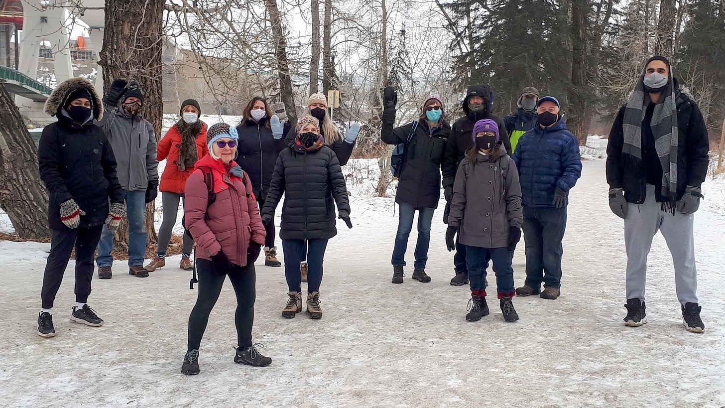 People out for a walk in the snow. People are wearing masks and hats, but it's clear that they're in their 30s, 40s, and 50s, not elderly