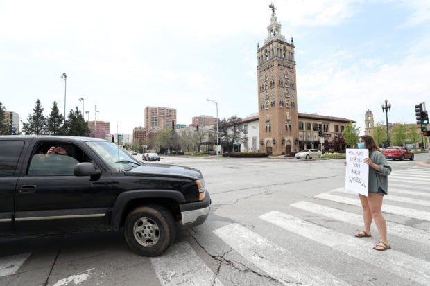 McKinley Callin of Lawrence, Kansas, a supporter of the stay-at-home order, blocks traffic during a protest against the order at the Country Club Plaza on April 20, 2020 in Kansas City, Missouri. Jamie Squire/Getty Images