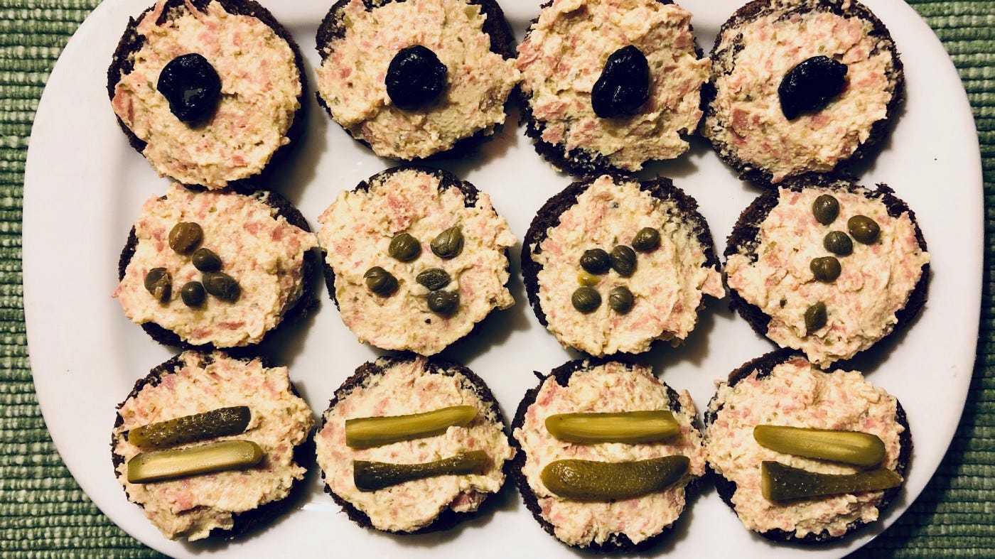 Canapes topped with olives, capers, and cornichons