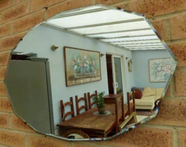 An oval-shaped mirror with no frame