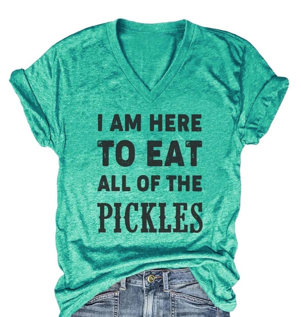 A photo of a green shirt with "I am here to eat all the pickles" in large letters on the front