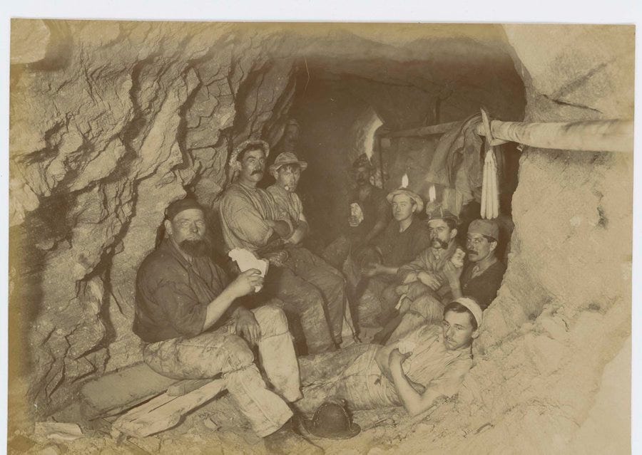 Black and white photo of miners eating pasties.