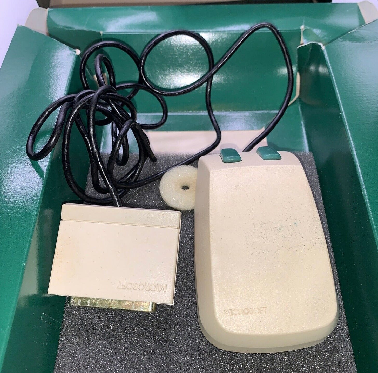 Photo of the original Microsoft Mouse in a box. It is called "green eyed" because it had two green buttons.