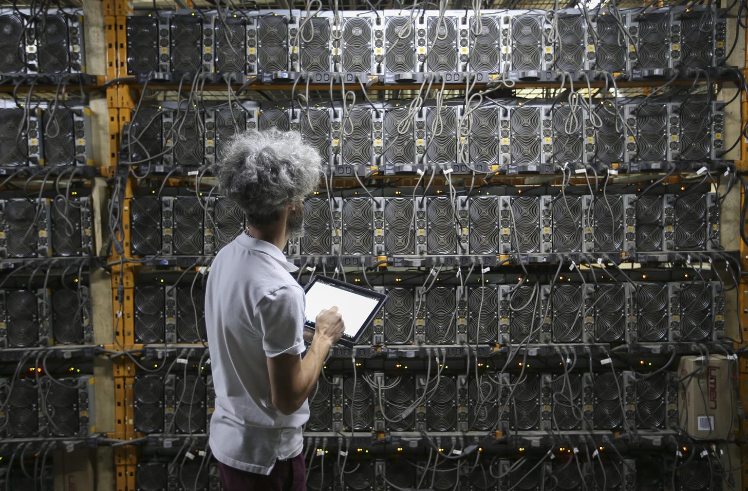 A worker inspects Bitcoin mining machines.&nbsp;