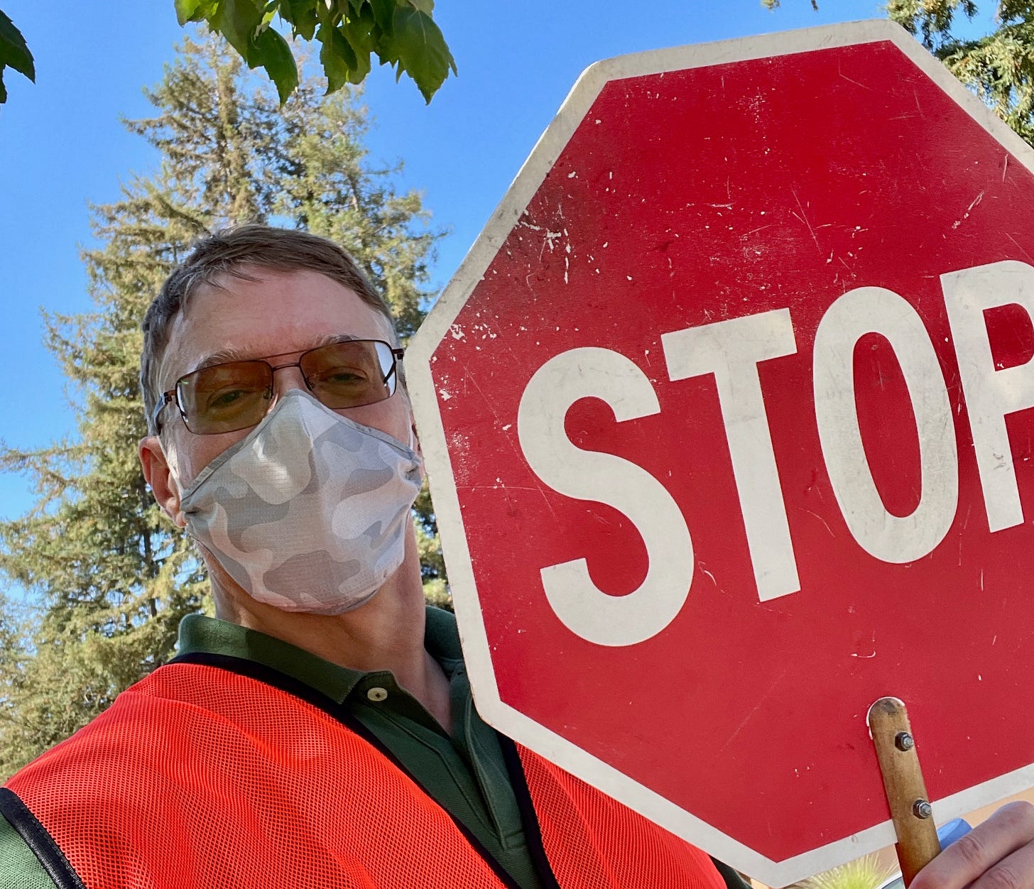 Man in glasses & mask with big stop sign
