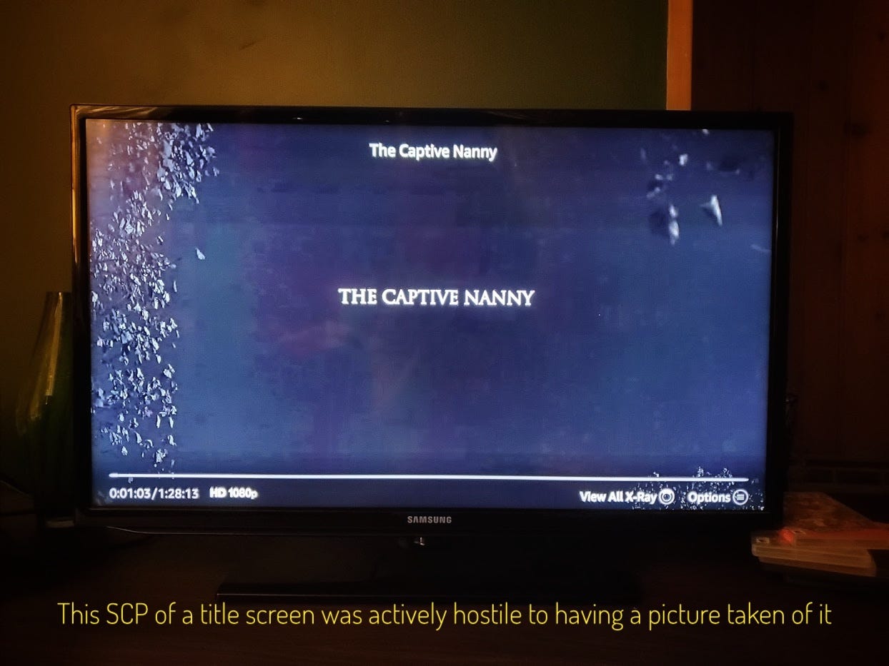 A blurry black title screen with leaves on the side of the screen, captioned "This SCP of a title screen was actively hostile to having a picture taken of it"