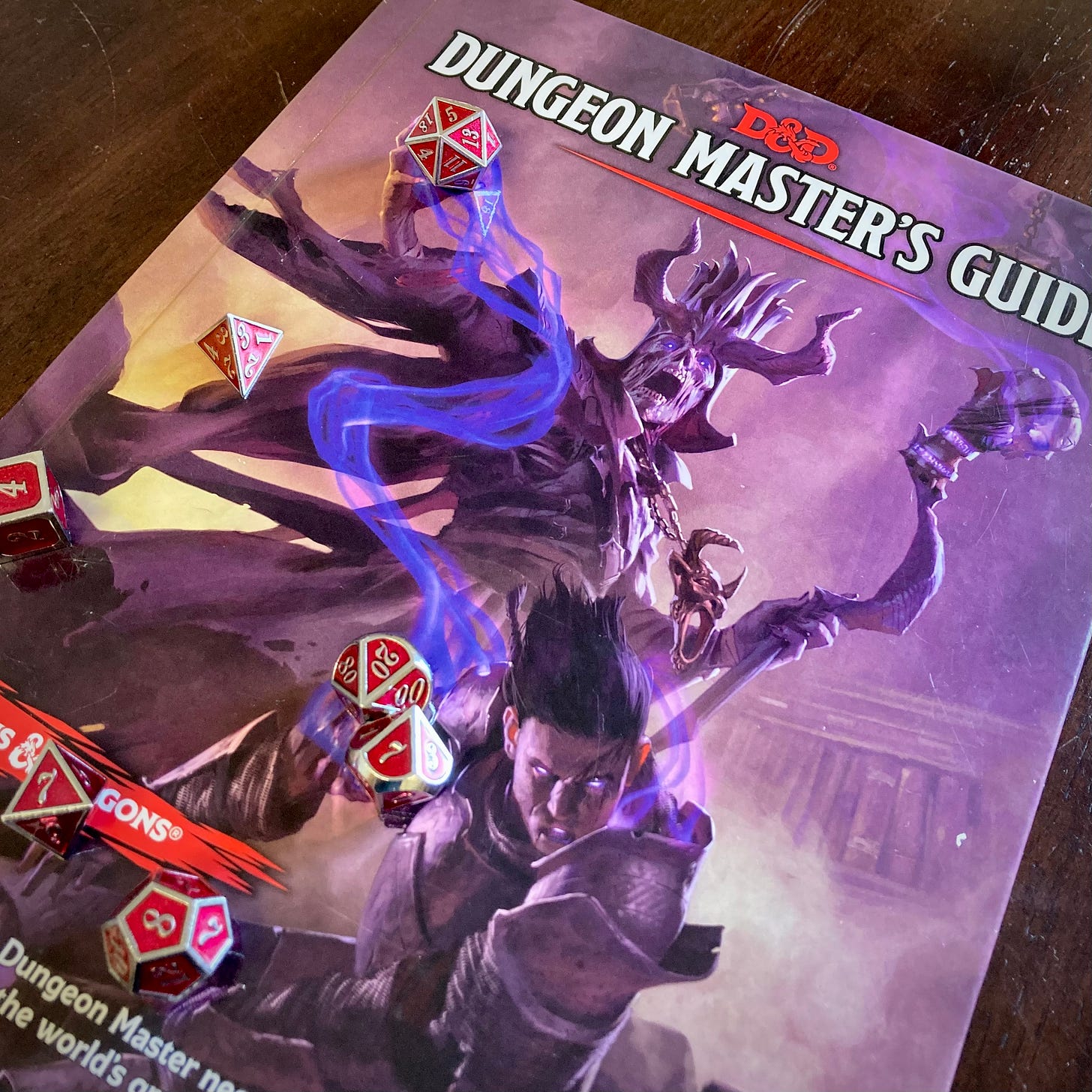 picture of the dungeon master's guide with dice resting on the cover