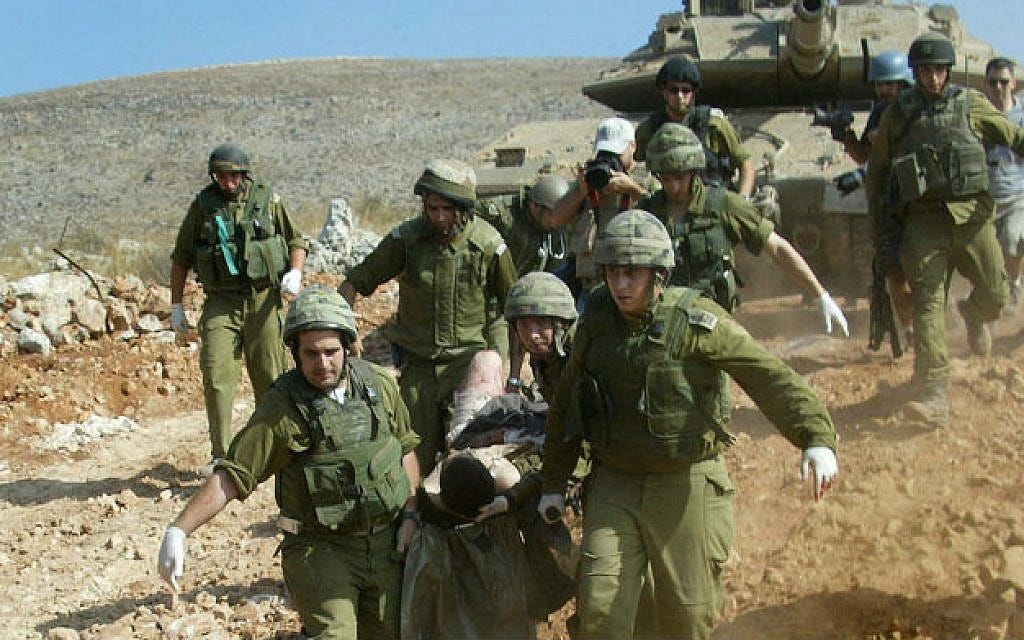 Soldiers evacuate a wounded comrade during the Second Lebanon War, on July 24, 2006 (Haim Azoulay/ Flash 90/ File)