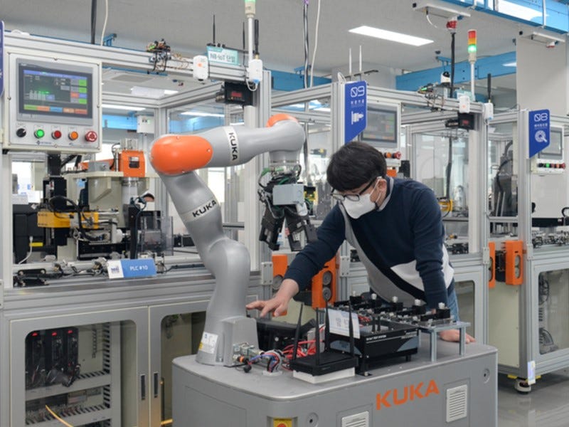 A researcher of the ETRI is controlling a mobile robot by using 5G technology in smart factory