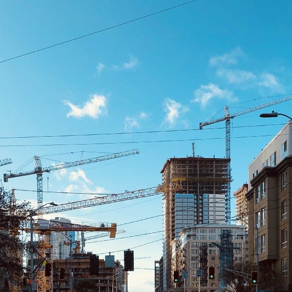 Seattle’s South Lake Union and Denny Way Under Construction On A Sunny Day With Multiple Cranes Spanning Across The Street