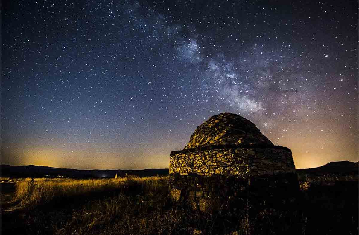 A view of a reconstructed hut at the Nuraghe Antine site at night. 
