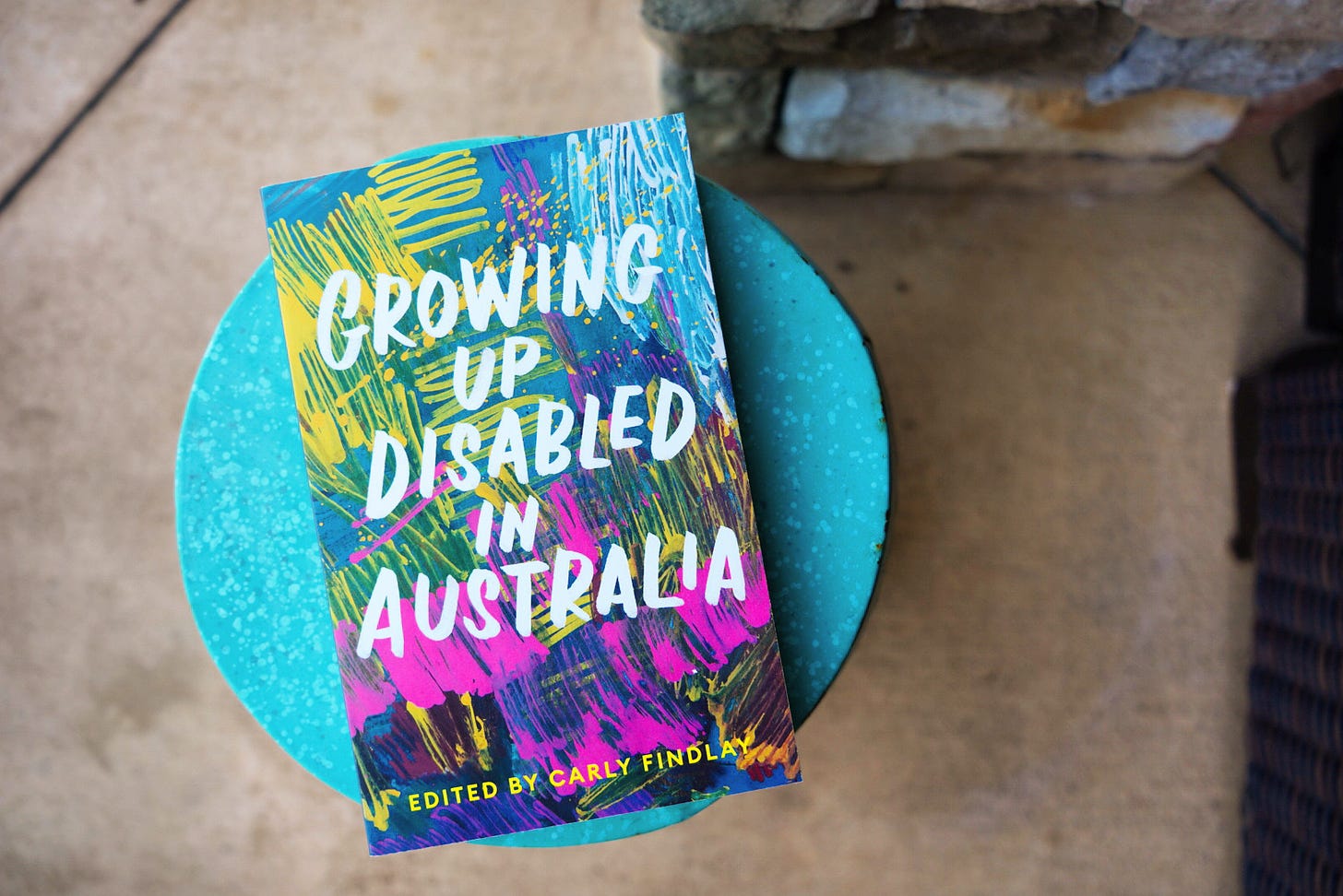 a photo of the book Growing Up Disabled in Australia sitting on a blue side table