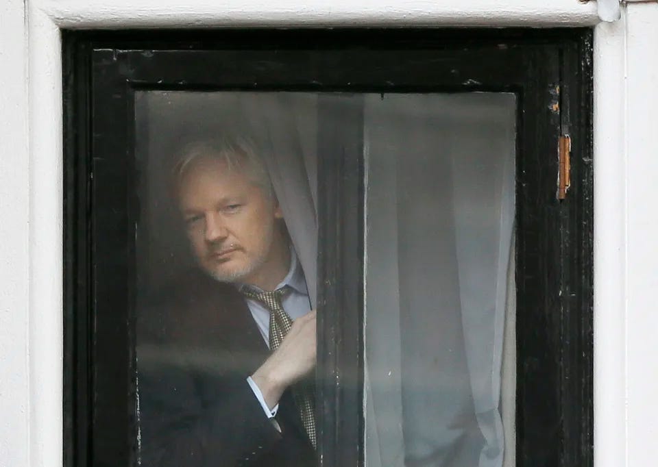 Wikileaks founder Julian Assange appears at the window before speaking on the balcony of the Ecuadorean Embassy in London on Feb. 5, 2016. (Kirsty Wigglesworth/AP)