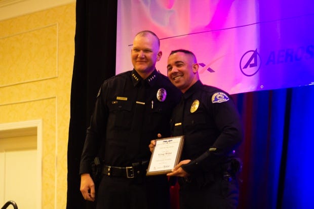 Redondo Beach Police Chief Joe Hoffman (left) presents a Livesaving...