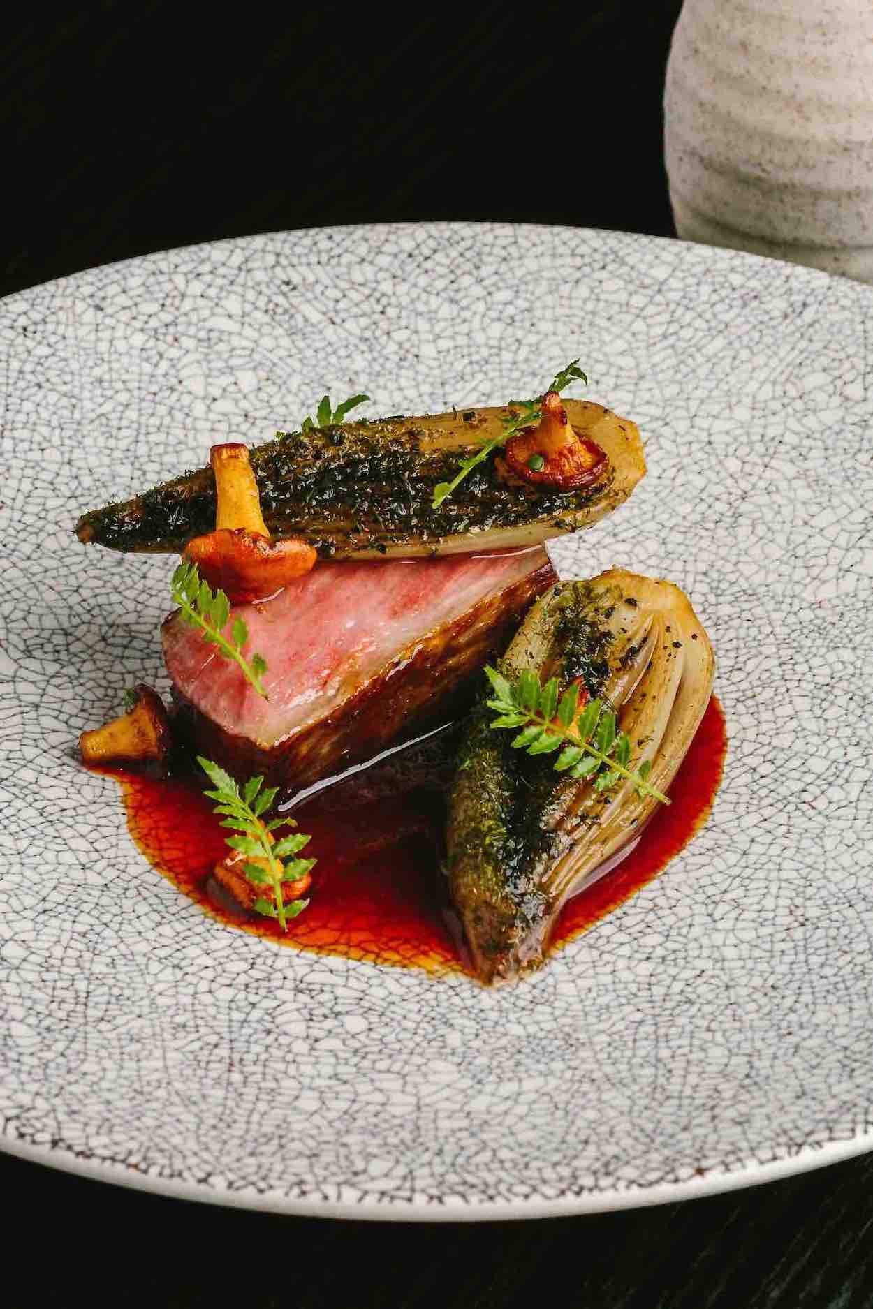 Kumamoto Wagyu, roasted piquillo sauce, chanterelle mushrooms, banana shallots, and beef broth