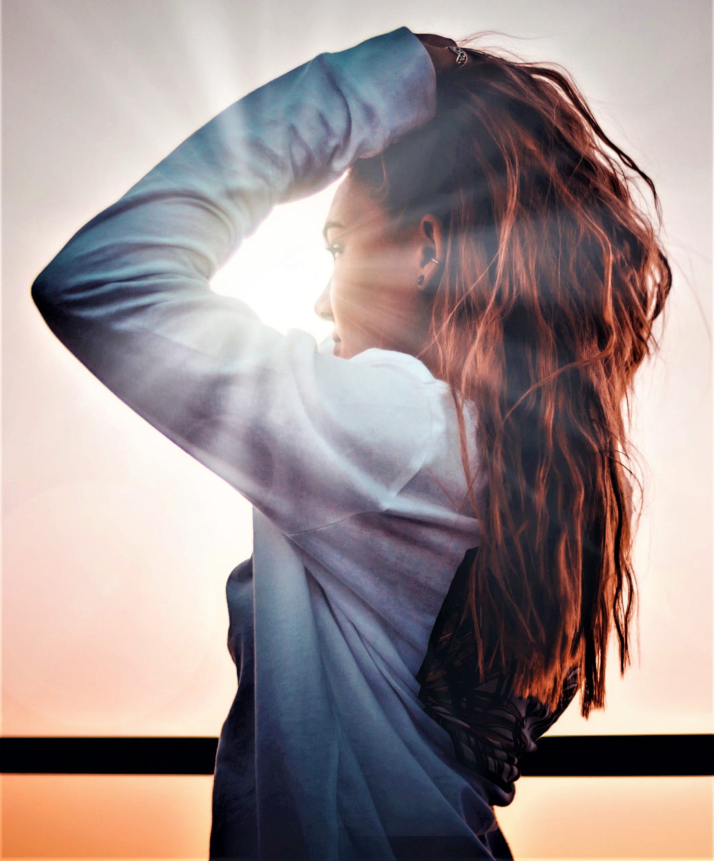 side view of girl with long red hair looking into sunny sky side view of girl with long red hair looking into sunny sky