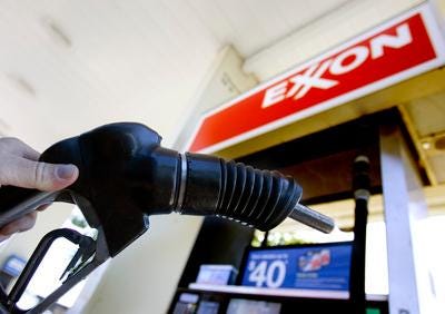 ** FILE ** In this July 31, 2008 file photo, a customer holds a gas pump handle at an Exxon station in Vancouver, Wash. Exxon Mobil Corp. sets quarterly profit record for U.S corporations at $14.83 billion, Thursday, Oct. 30, 2008.(AP Photo/Don Ryan, file)