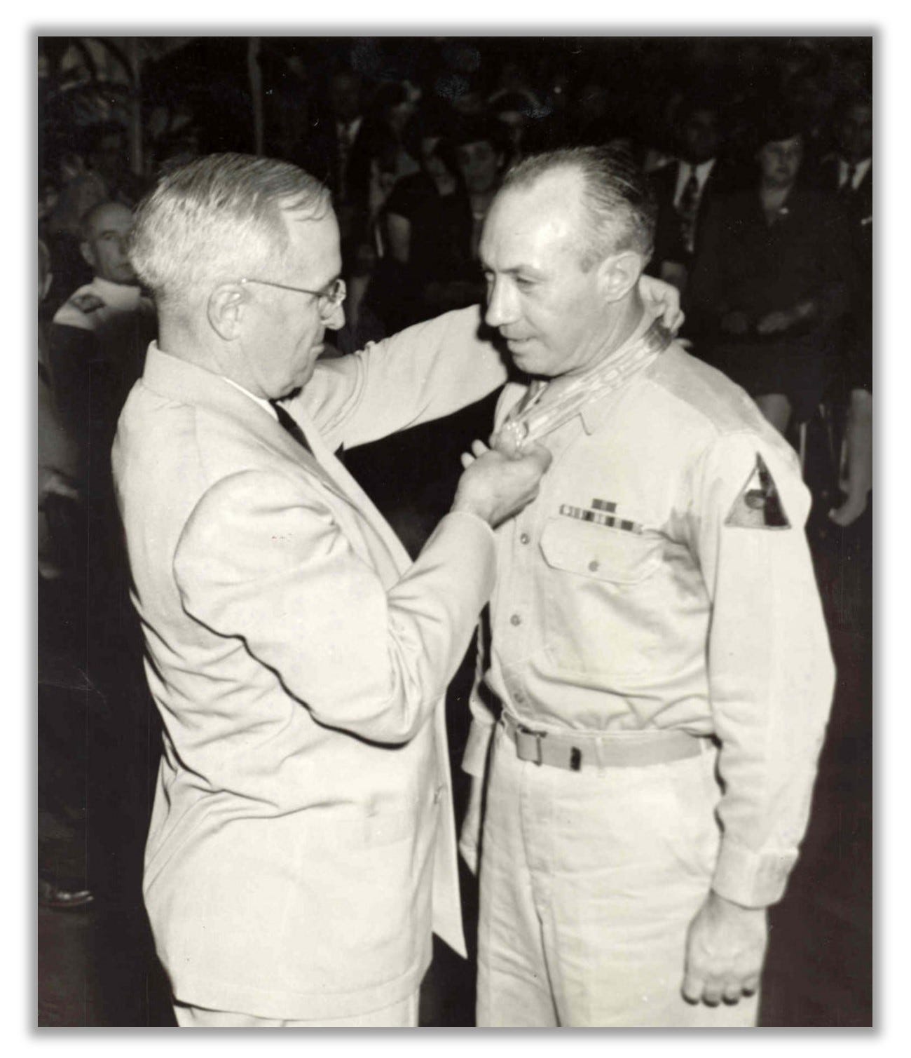 Harry S Truman hangs a Medal of Honor around George Turner's neck.
