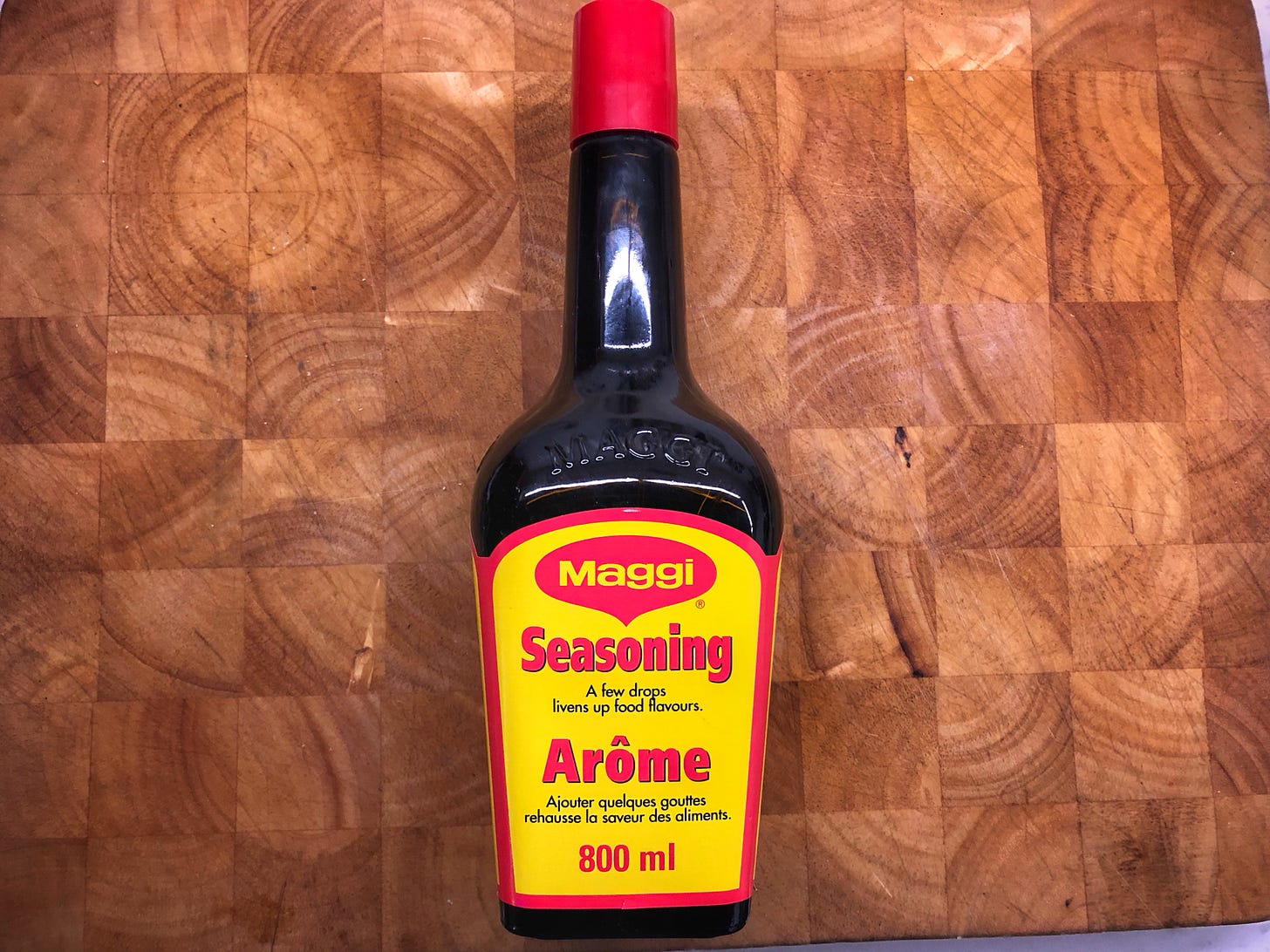 An 800ml bottle of Maggi Seasoning on a cutting board
