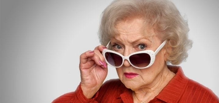 Betty White holding white sunglasses on her nose