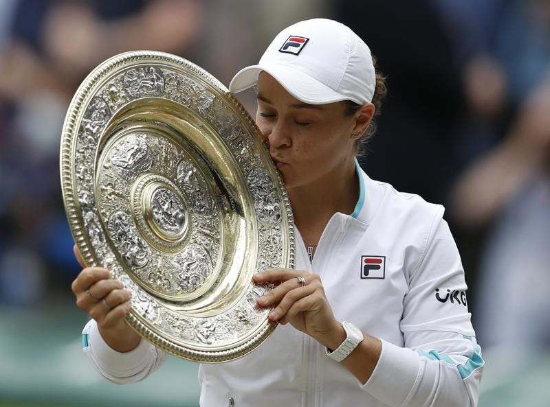 Australia's Ashleigh Barty poses with the trophy for the media after winning the women's singles final after defeating the Czech Republic's Karolina Pliskova on day twelve of the Wimbledon Tennis Championships in London, Saturday, July 10, 2021.  In a shock announcement Wednesday, March 23, 2022, No. 1-ranked Barty announced her retirement from tennis. (Pete Nichols/Pool Via AP, File)