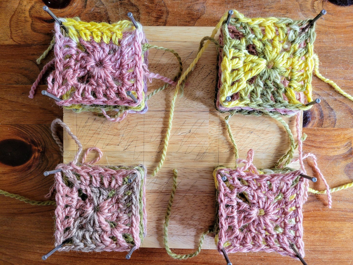 Photo of granny squares blocking on a piece of wood.