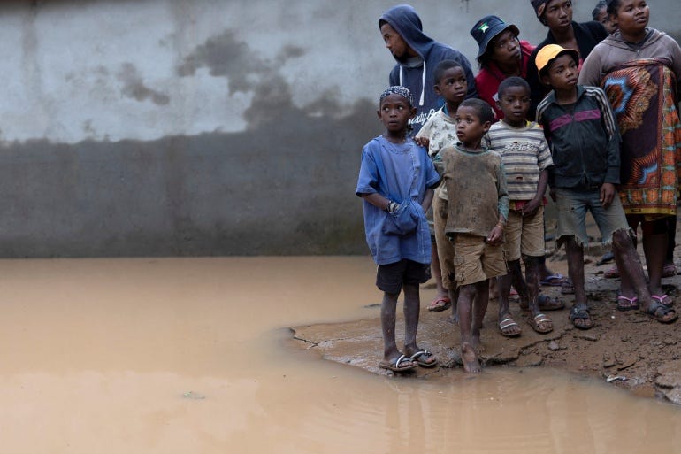 Children stand by brown flood waters in Fianarantsoa, Madagascar