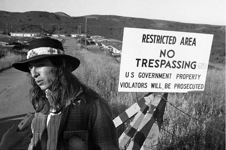 Photo of John Trudell with no trespassing sign