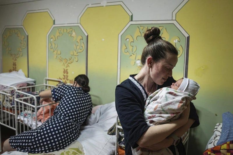 A woman holds a newborn inside a Ukrainian hospital