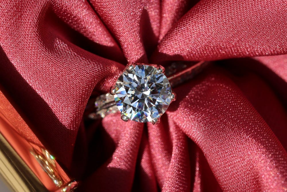 silver diamond ring on red textile silver diamond ring on red textile