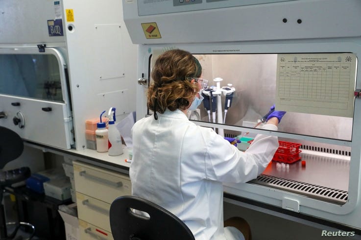 FILE - A scientist works on a vaccine against the coronavirus at a facility in Oxford, Britain, June 24, 2020. British intelligence officials are putting research facilities high on the list of potential Chinese targets. 
