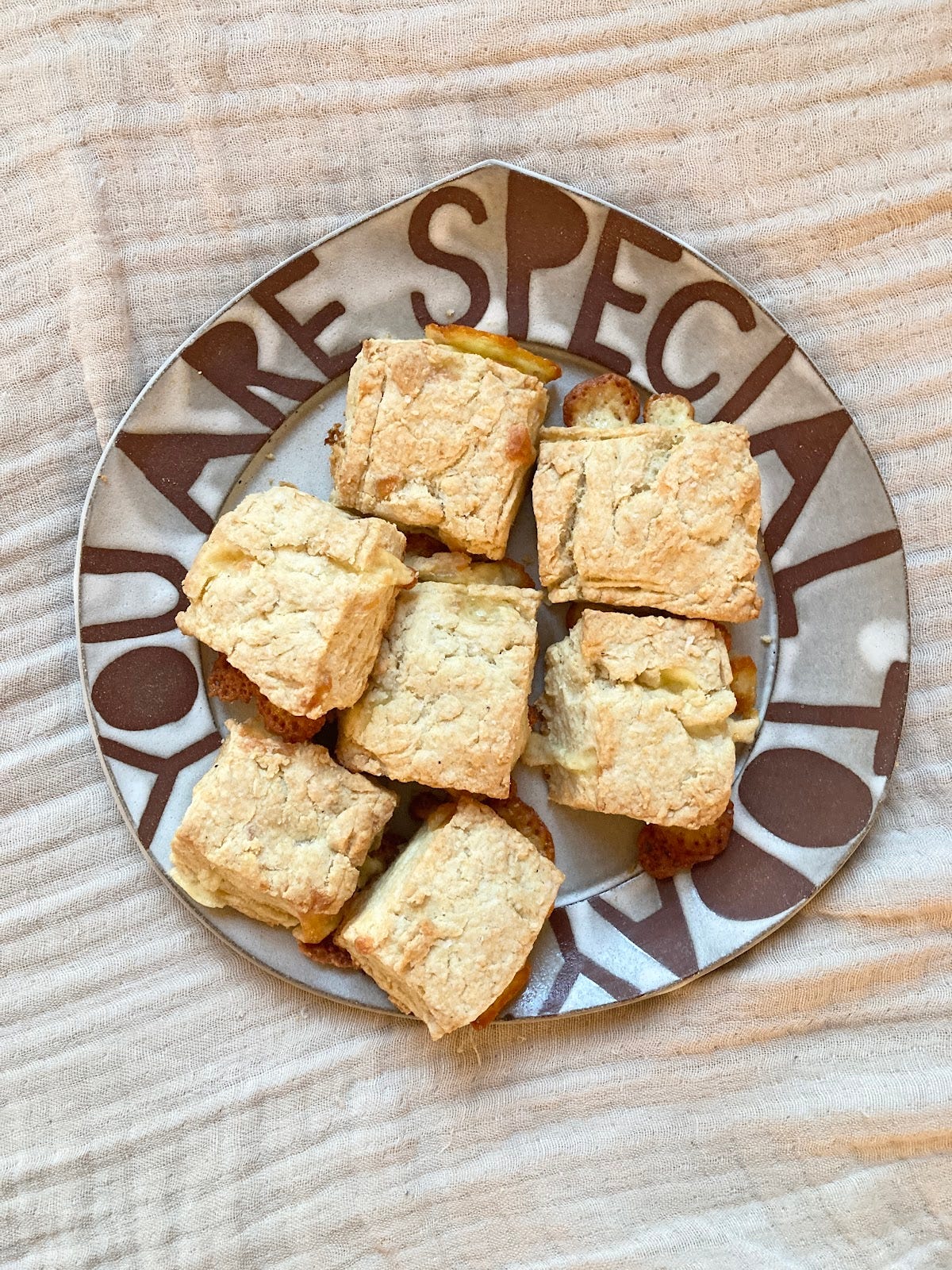 Image of a grey and brown plate that says "You Are Special Today" on the rim. The plate is filled with flaky biscuits.