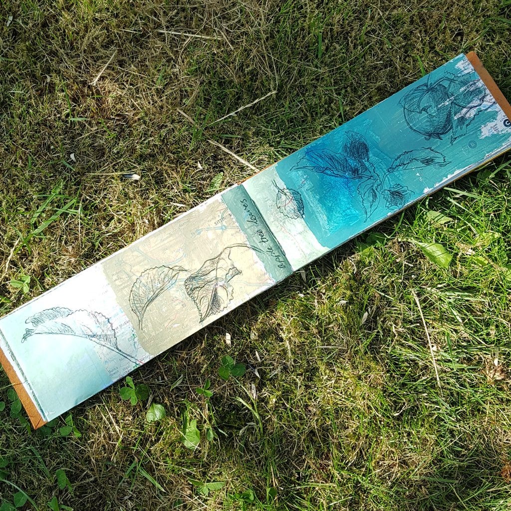 Handmade sketchbook lying on the grass in my garden. Photo taken July 2021.
