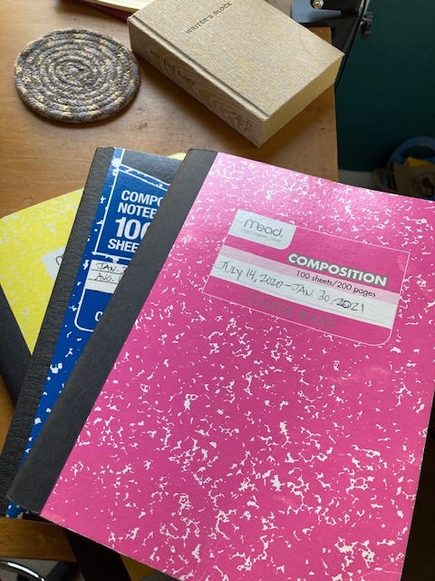 Three composition notebooks sitting on a desk