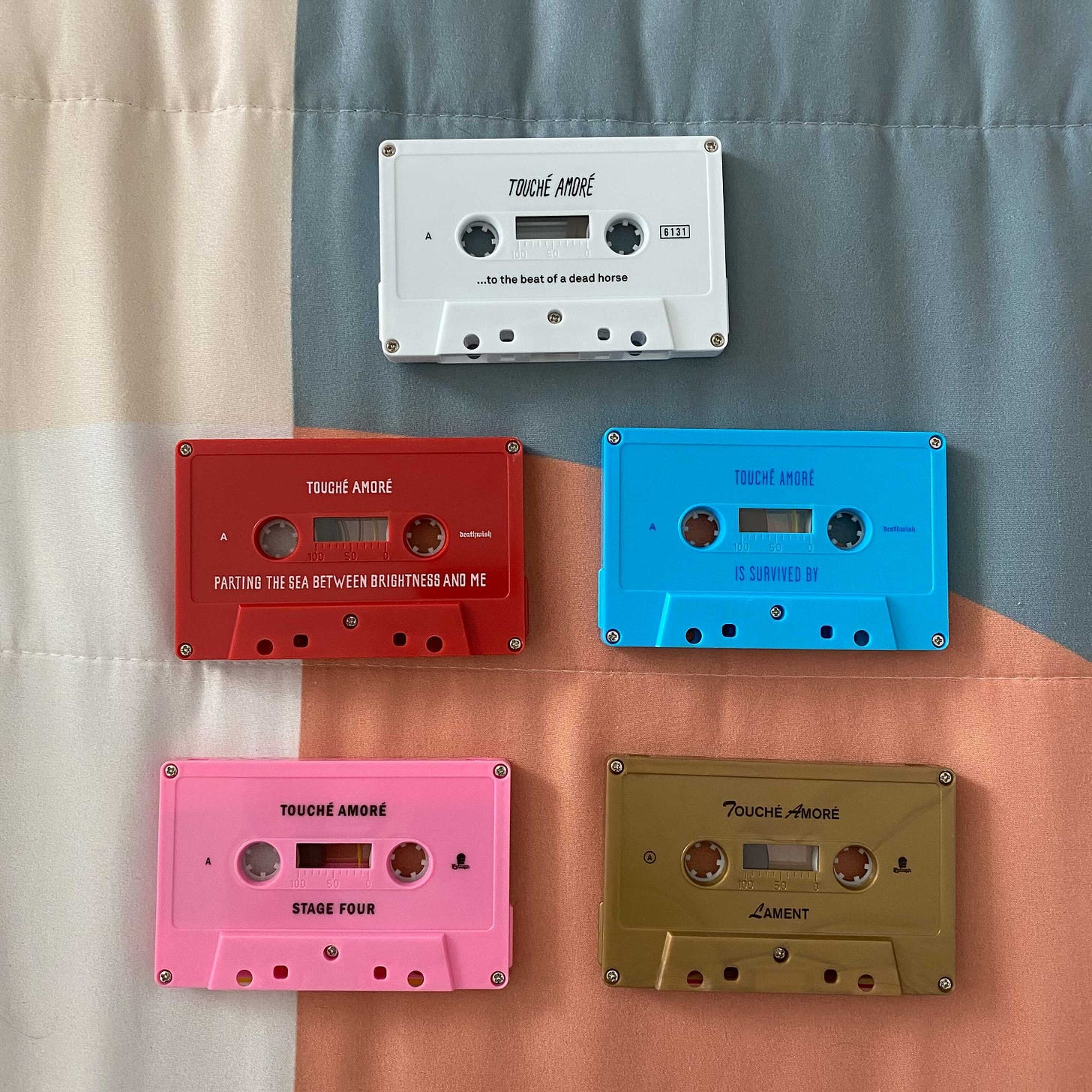 a picture of the five Touché Amoré albums on cassette tapes