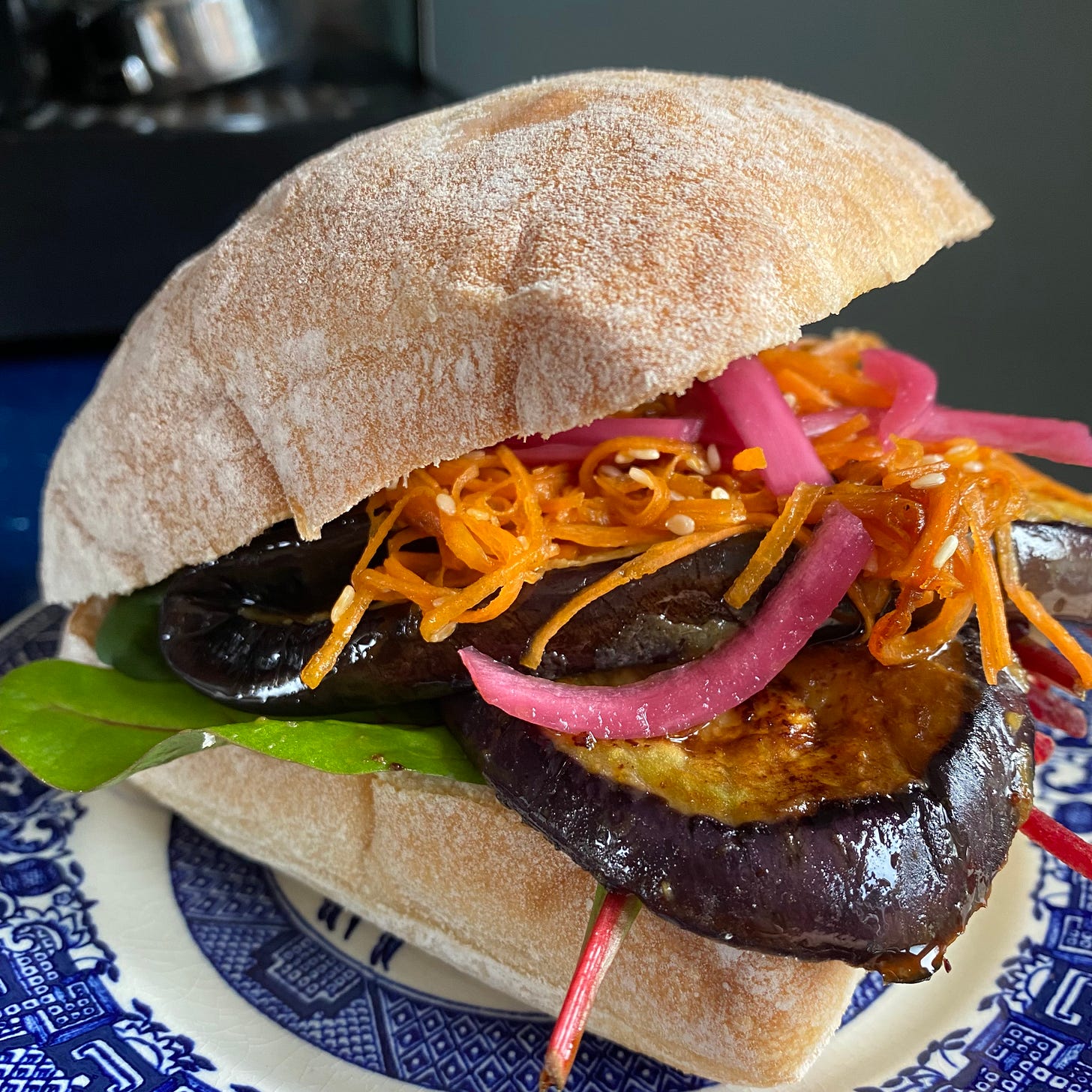 Ciabatta roll filled with sliced aubergine, shredded carrot, pickled red onion and salad.