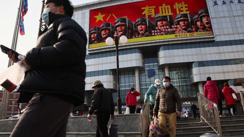 An advertisement of the People's Liberation Army overlooks a street scene in Beijing on the day Chinese President Xi Jinping and his U.S. counterpart Joe Biden hold a virtual summit, in Beijing, China, November 16, 2021.