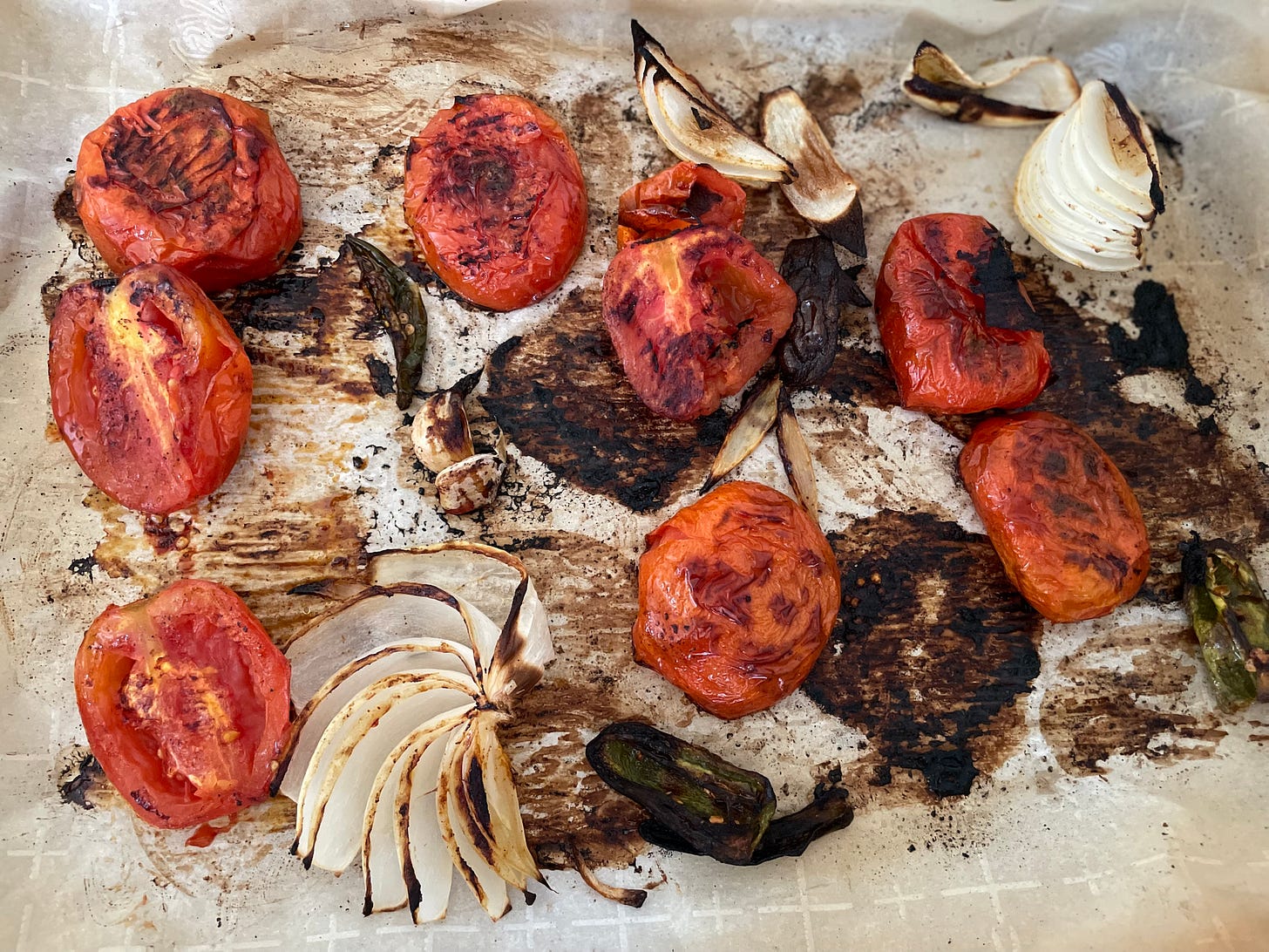 Roasted tomatoes onions garlic peppers on sheet pan