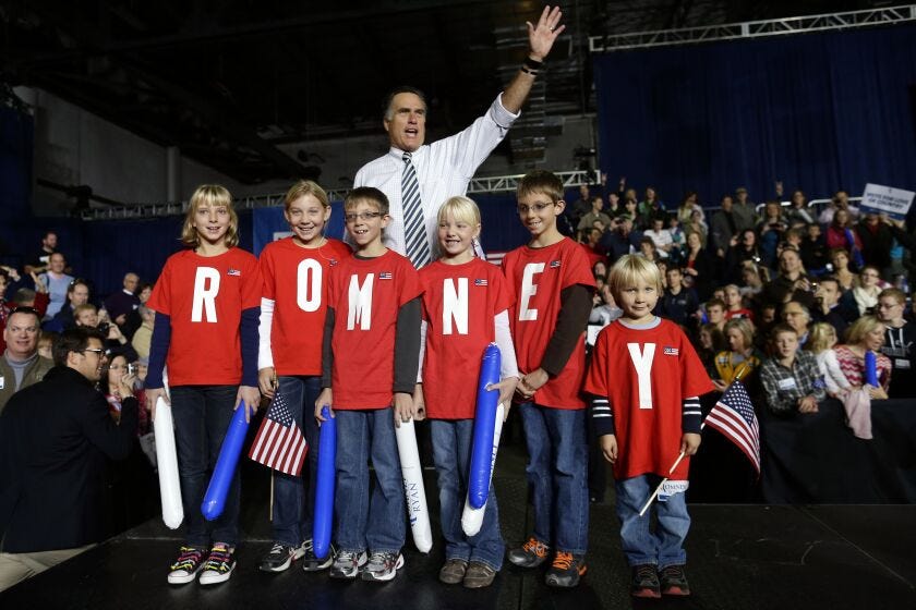 Then-Republican presidential candidate and former Massachusetts Gov. Mitt Romney poses with children wearing shirts which spell out “Romney” as he campaigns at the Iowa Events Center, in Des Moines, Sunday, Nov. 4, 2012.