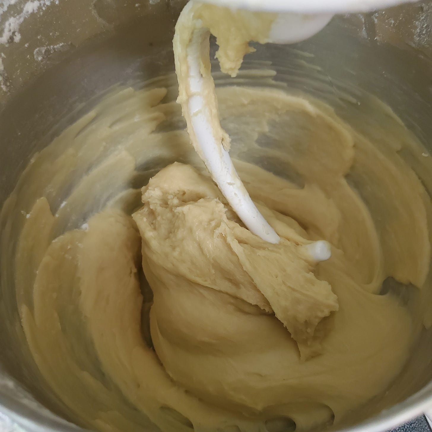 Extremely wet bread dough in the bowl of a stand mixer.