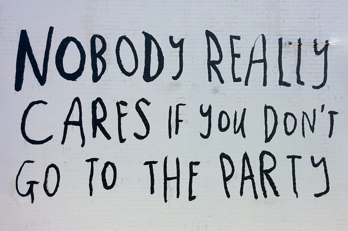 handwritten text on a wall that reads nobody cares if you don't go to the party