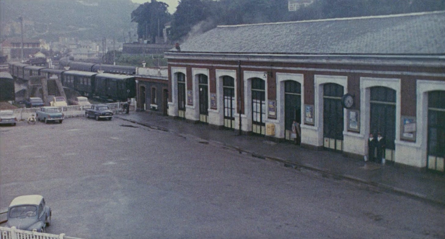 A dull, gray and brown train station on a rainy day.