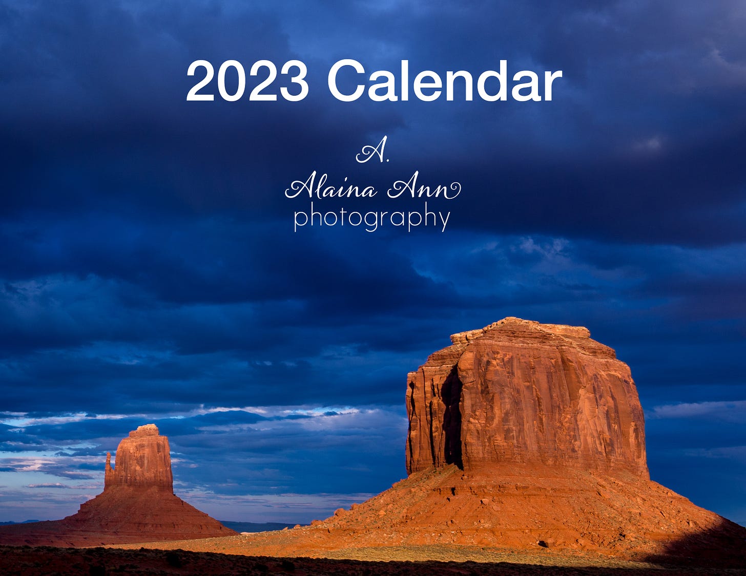 Cover of a 2023 calendar featuring sunlit red rock buttes with blue clouds across the sky.