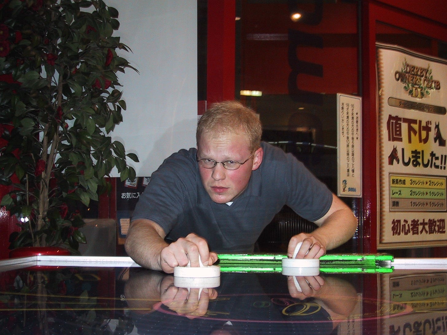 The author in 2003, playing air hockey at a Japanese arcade.