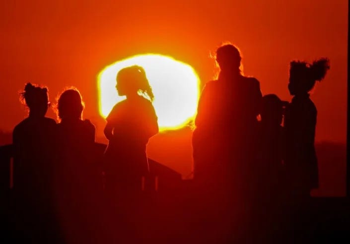 LONG BEACH, CALIF. - SEPT. 1, 2022. The blazing sun silhouettes visitors to Signal Hill after another hot day across Southern California. A brutal heatwave is expected to last through the Labor Day weekend. (Luis Sinco /. Los Angeles Times)