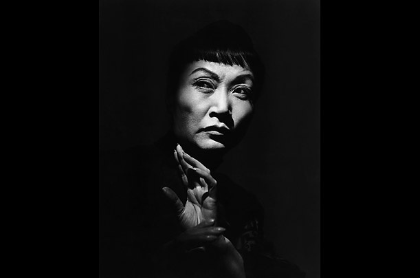 A dramatic black and white portrait of a markedly older Anna May Wong
